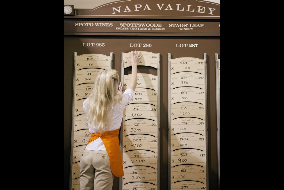 A VOLUNTEER ADDS A NEW BARREL BID TO THE LEADERBOARD AT RAYMOND VINEYARDS